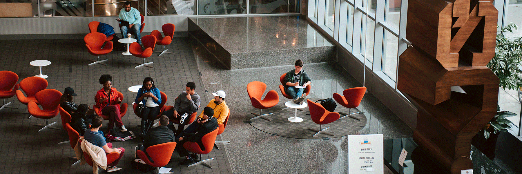 Students sitting in a circle and conversing in the campus center.