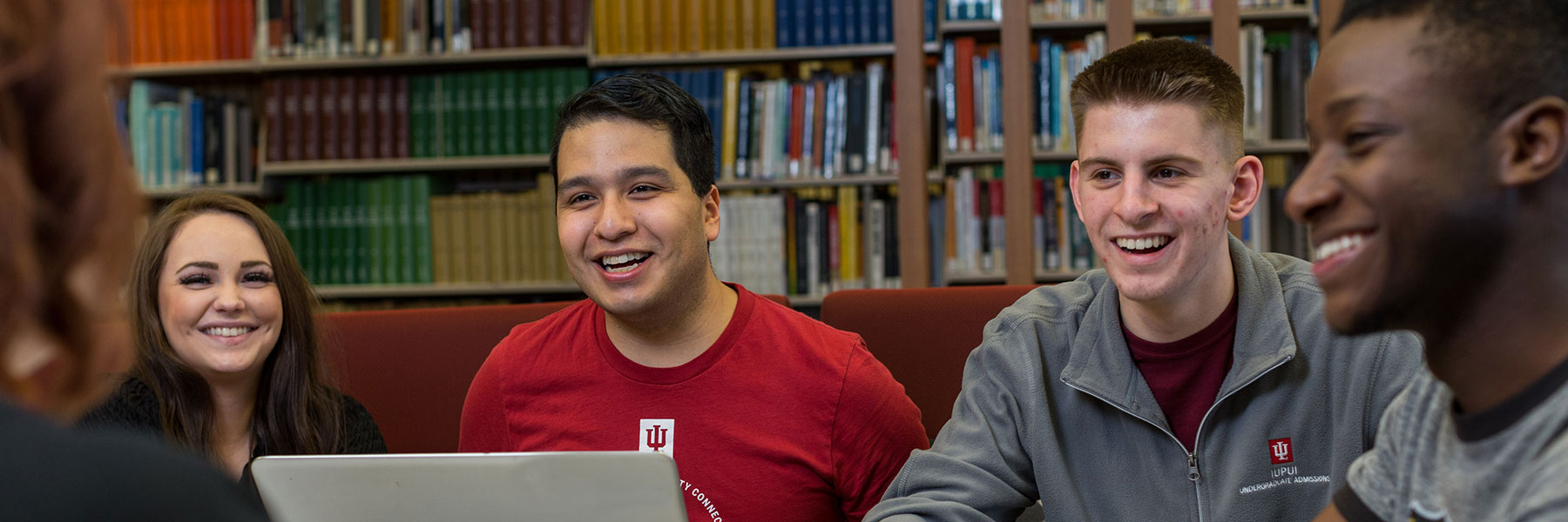 Four IUPUI students work together in the library and laugh