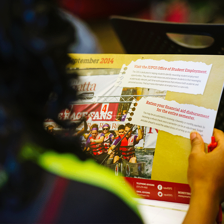 A student reading an advertisement for the Office of Student Employment.