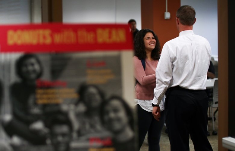 Dean Jay Gladden shaking the hand of a student. 