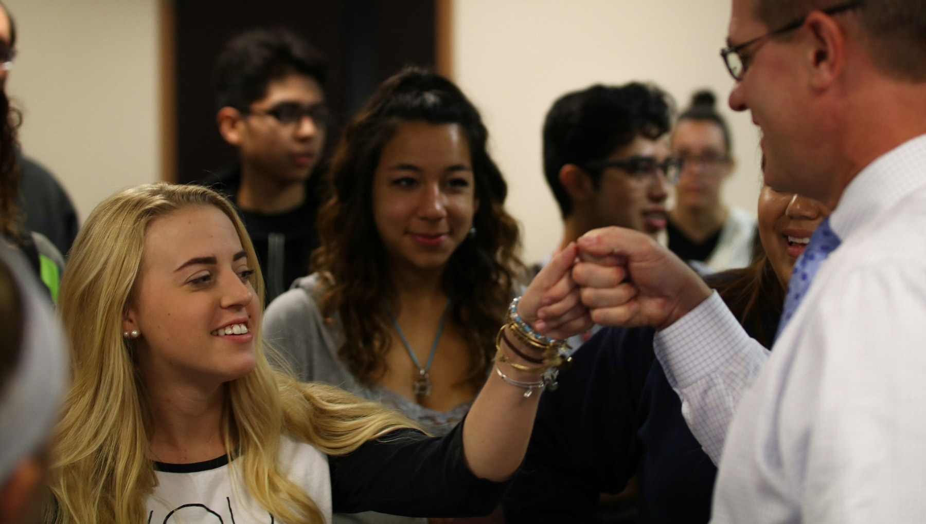Dean Jay Gladden fist bumping with a student